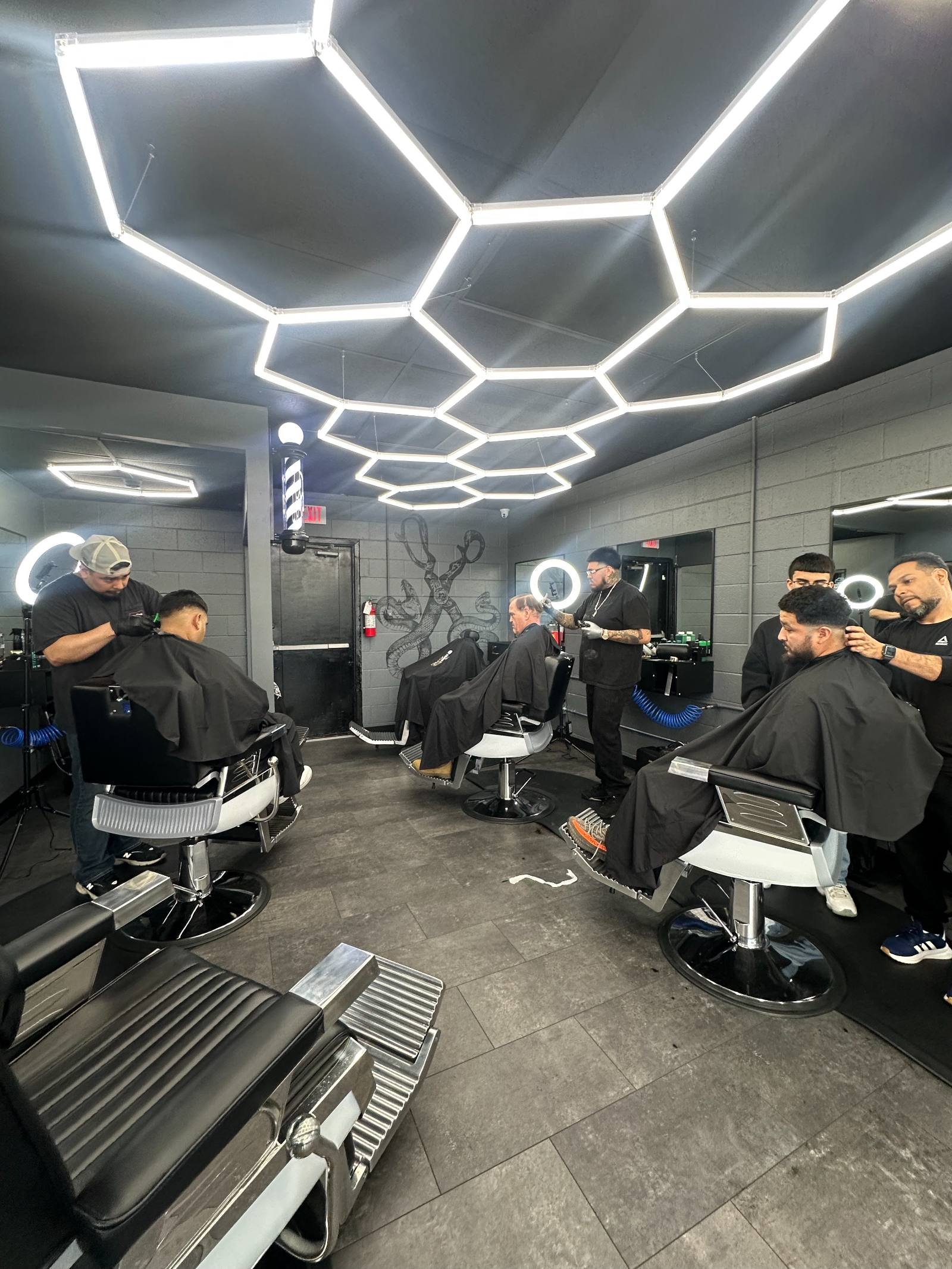 Students cutting hair on the academy clinic floor